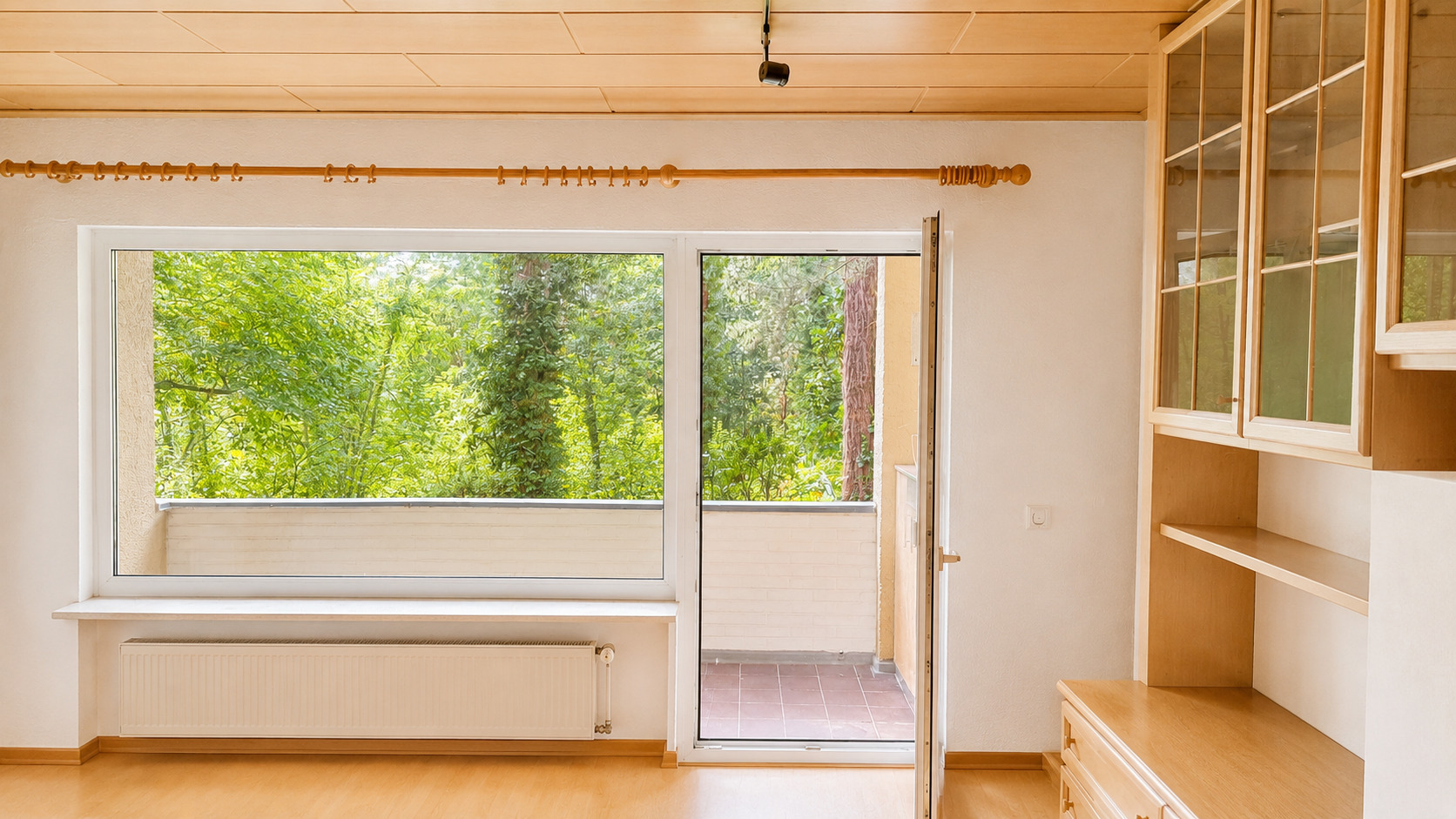 KI-bearbeiteter Wohnbereich mit großer Fensterfront und Loggiazugang